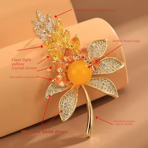 Detailed macro view of wheat leaf brooch with amber bead and sparkling zircon inlay