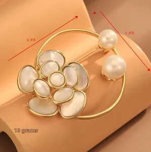 Détail macro de broche fleur dorée avec pétales en nacre, perles et dimensions 4.8cm x 3.9cm