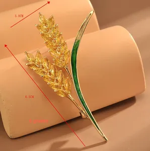 Dettaglio della spilla a spiga dorata con zirconi gialli e misure 6,5cm per 3,8cm