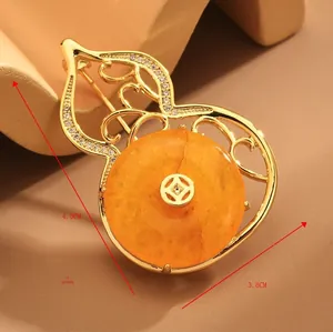 Detailed close-up of golden gourd brooch featuring zircon accents and amber stone inlay