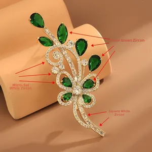 Détail macro d'une luxueuse broche fleurie avec zircons verts et sertissage micro-pavé