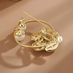 Broche fleur dorée élégante avec pétales en nacre et perles sur fond marron chaud