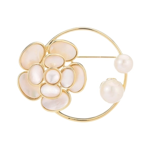 Broche fleur dorée élégante avec pétales en nacre et perles blanches sur fond blanc pur