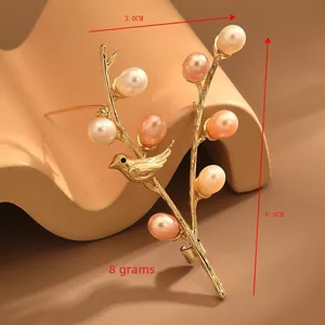 Detail shot of golden bird on branch brooch with pearls, sized 3.0cm by 6.0cm
