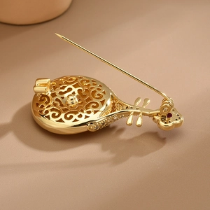 Broche élégante en forme de luth dorée avec micro-zirconiums et design évidé raffiné