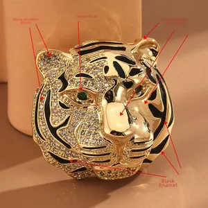 Macro detail of tiger brooch with green zircon eyes and black enamel stripes on gold plating