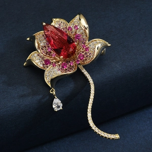 Elegant gold lotus brooch with a large pear-cut red gemstone and micro-set zircon petals