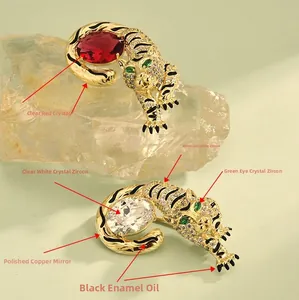 Detail of tiger brooches with zircon stones, black enamel stripes and copper mirror polish