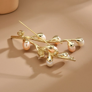 Elegant gold twig brooch with freshwater pearls and delicate bird-inspired design