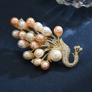 Elegant gold peacock brooch with freshwater pearls and sparkling white zircon inlays