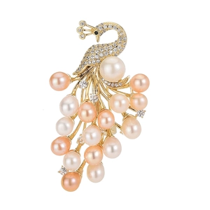 Golden peacock brooch with sparkling crystals and colorful freshwater pearls on white base