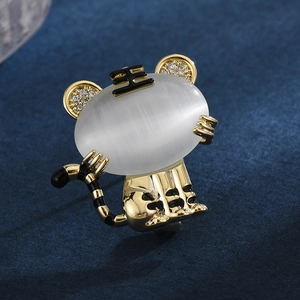 Cartoon tiger brooch with cat eye stone and gold-tone finish on deep blue velvet background
