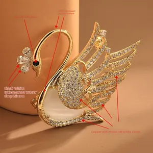 Macro shot of swan brooch showing golden plating, micro-set zircons and white opal stone