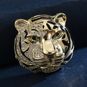 Macro shot of gold tiger head brooch with crystal pavé and green emerald eyes