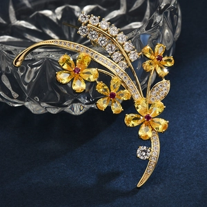 Broche florale élégante avec zircon jaune et rouge sur fond en velours bleu foncé