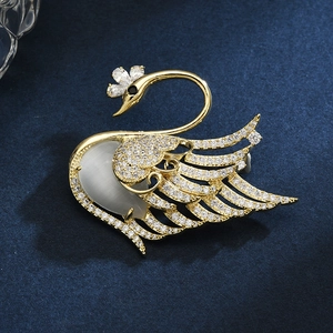 Elegant gold swan brooch with micro-set cubic zirconia and opal on deep blue velvet
