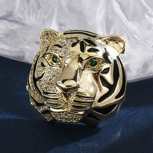 Macro detail of golden tiger head brooch with white cubic zirconia and green gem eyes