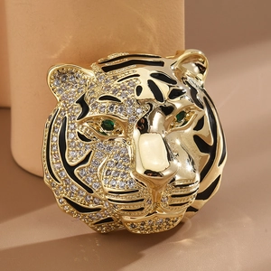 Elegant tiger head brooch with gold alloy, black enamel, and sparkling green gem eyes
