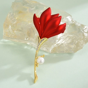 Elegant red rose brooch with zircon crystals and pearl on light green backdrop