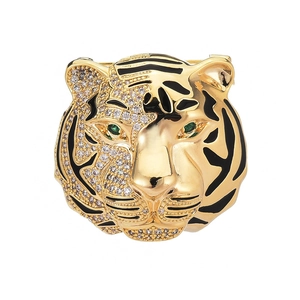 Tiger head brooch in gold metal with black enamel, white zircons, and green gem eyes