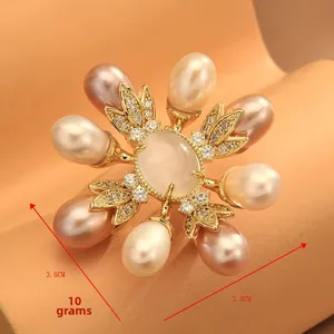 Macro detail of vintage floral brooch with freshwater pearls and cat eye stone inlay