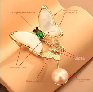Détail de la broche papillon en nacre avec zircon vert et pendentif en perle