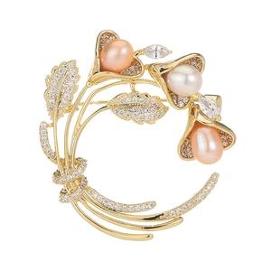 Eleganter goldener Blumenanstecker mit Süßwasserperlen und Kristallen auf weißem Grund