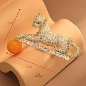 Gros plan détaillé de la broche léopard avec zircons blancs et yeux en pierre verte