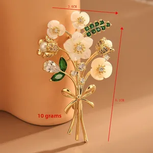 Vue détaillée de la broche bouquet en nacre dorée, mesurant 3,6 cm par 6,1 cm environ