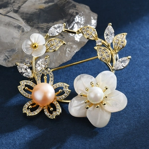 Broche fleur en coquillage avec perle d'eau douce et zircons sur base plaquée or 18k