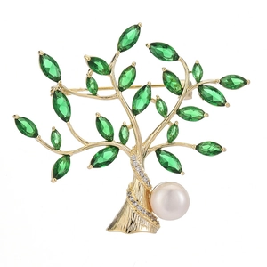 Elegant Tree of Life brooch with emerald green crystals and a white pearl on gold finish