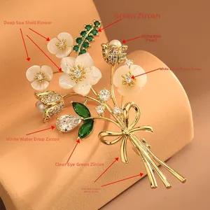 Détail macro d'une broche bouquet en nacre avec zircon vert et finition en cuivre poli