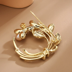 Eleganter goldener Winden-Broschenstecker mit Süßwasserperle und funkelnden Kristallen