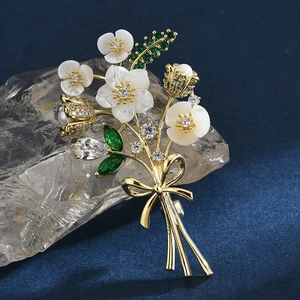 Élégante broche bouquet en nacre avec zircone cubique et détail de nœud doré