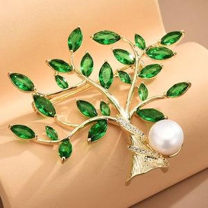 Elegant gold tree branch brooch with green crystals and a large white pearl accent