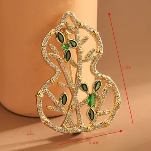 Macro detail of gold-plated gourd brooch with white zircons and dimensions 4.3x3.1cm