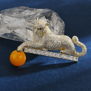 Détail de la broche léopard avec zircons micro-pave et perle orange sur velours bleu