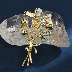 Broche bouquet dorée avec nacre blanche et zircons brillants sur fond bleu élégant