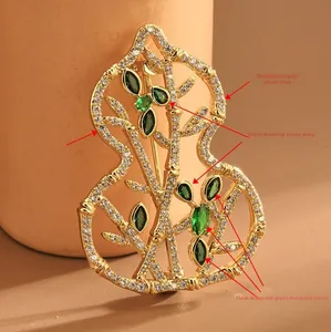 Detail of gold-plated gourd brooch featuring micro-set white and green cubic zirconia