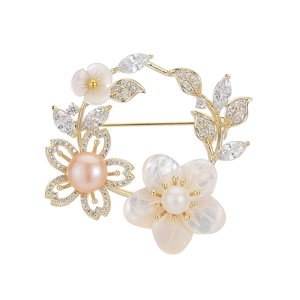 Broche élégante en fleurs de nacre avec perles et cristaux sur fond blanc pur