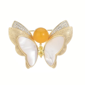 Broche papillon dorée élégante avec nacre blanche et accents de pierre d'ambre