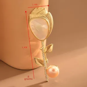 Dettaglio macro della spilla a tulipano con petali di madreperla, perla rosa e oro