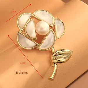 Detail view of a rose-shaped brooch with mother of pearl petals and a central freshwater pearl