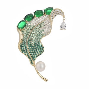 Elegant gold-plated leaf brooch with green zircons, pearls, and teardrop pendant details