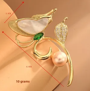 Detail view of butterfly brooch with white shell, pink pearl, and size markers 3.8cm x 6.0cm