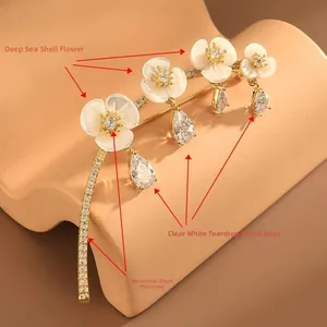 Close-up of shell flower brooch with micro-set zircons and dangling water drop pendants