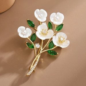 Elegant white shell flower bouquet brooch with green zircon crystals and gold finish