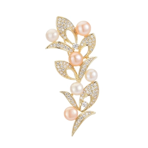 Elegante spilla a foglia dorata con perle d'acqua dolce e zirconi su sfondo bianco puro