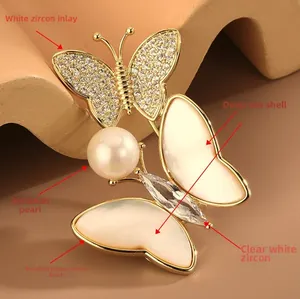 Vue détaillée de la broche papillon dorée avec pavage de zircons et incrustation de nacre