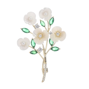 Elegant gold flower bouquet brooch with white shell petals, pearls, and green crystals